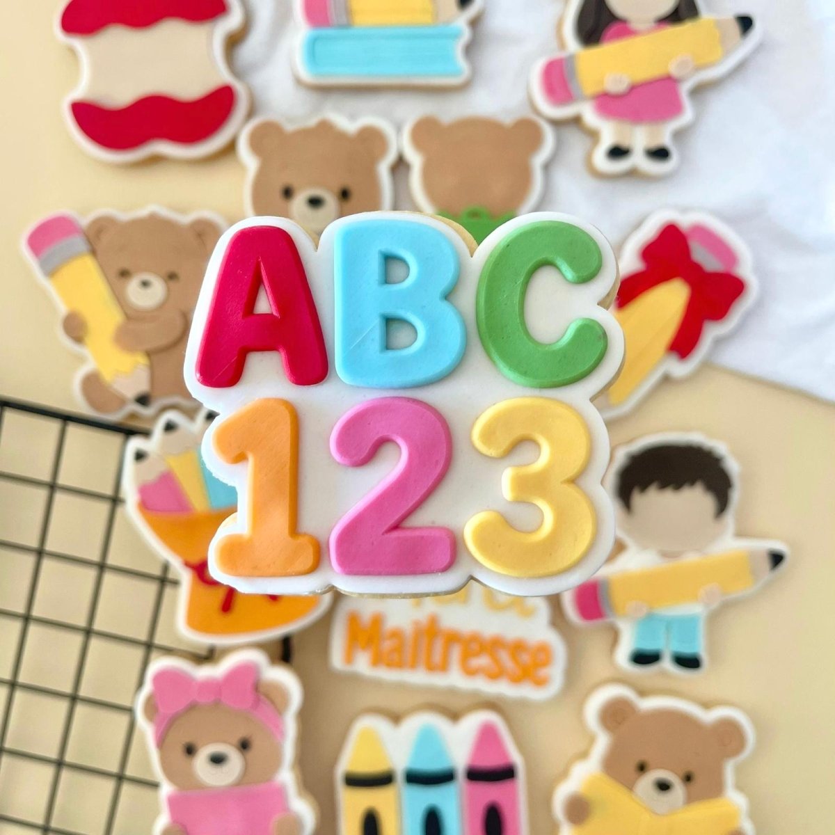 Koekje met ABC en 123 in regenboogkleuren tussen andere schoolkoekjes