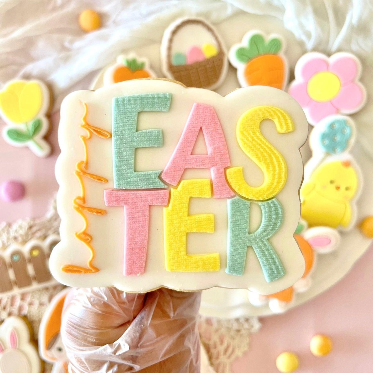 Happy Easter koekje in pastelletters in de hand