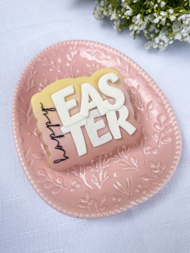 Happy Easter koekje op een roze paasbordje