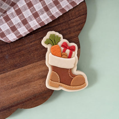 Koekje van een bruine laars met een wortel en een cadeautje